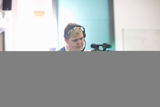 Young male college student filming in TV studio