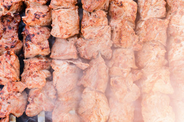 Marinated shashlik preparing on a barbecue grill over charcoal.
