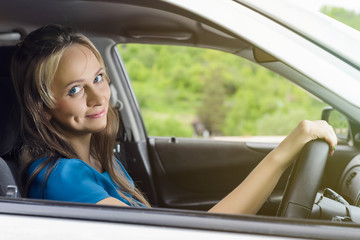 Portrait of happy female driver steering car