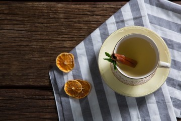 Cup of tea with cinnamon stick on napkin