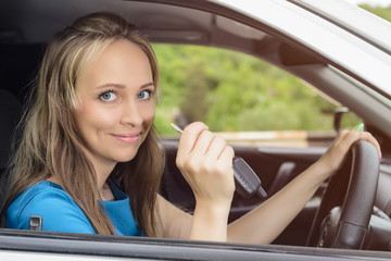 Attractive young happy woman shows keys from the car