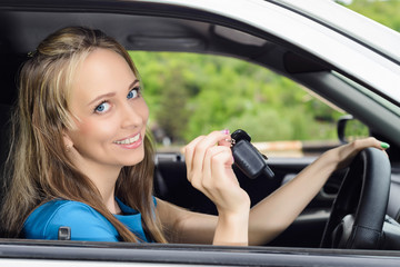 Fototapeta na wymiar Attractive young happy woman shows keys from the car