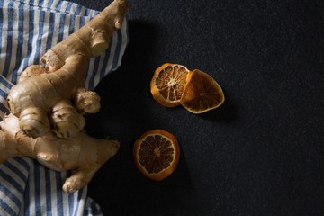Ginger and dried orange sliced on black background