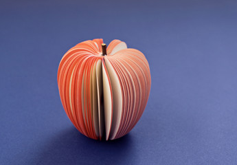 Fake Apple from paper on the purple violet background. Office notes diet concept, close up, soft...