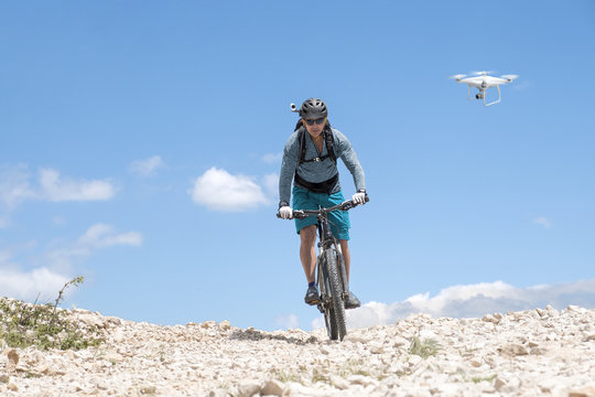 mountain biker with helmet camera followed by a drone