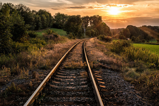 railway tracks, trees and sunset