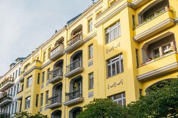 Fototapeta na wymiar yellow apartment building in a street at berlin