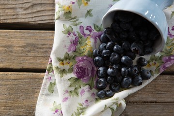 Blueberries spilling out of bowl on napkin