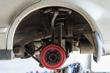 Car wheel arch without wheel, view of the hub, brake, struts