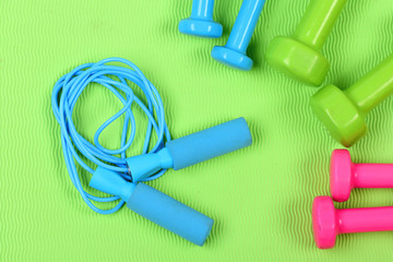 Dumbbells and skipping rope in cyan blue color