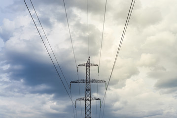 a high voltage power pylons against clouds