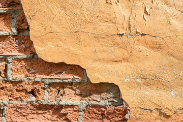 Clouse-up of the half plastered red brick wall in the sunlight. Red bricks built wall.