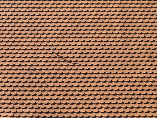 Background made from rooftiles with a hook throwing a shadow