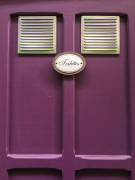 Toilet sign on the purple door