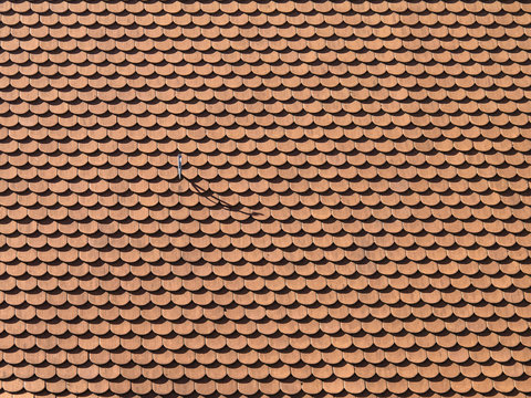 Background made from rooftiles with a hook throwing a shadow