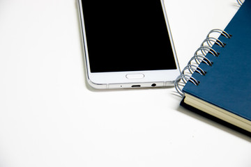 Office table with notepad and smartphone. View from above with copy space for text
