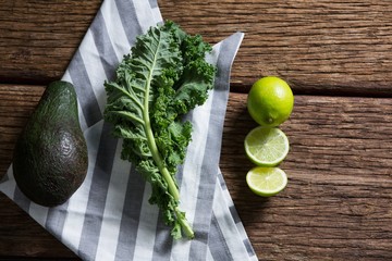 Mustard greens, avocado and lemon on wooden table