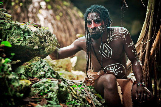 Black man with dreadlocks in the image of the Taino Indian in habitat, body painting Taino symbols