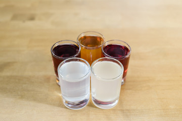Glasses with alcohol of different colors on a wooden table