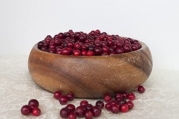 Berries cranberries in a wooden handmade dish on a light background