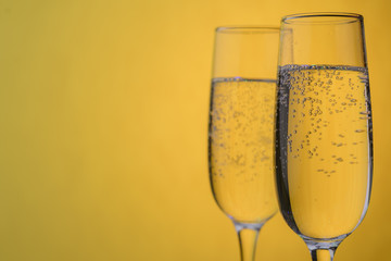 Glasses of champagne on a yellow background