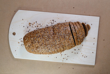 evenly sliced brown bread on wooden board for cutting