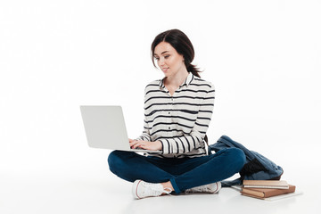 Portrait of a cute teenage girl with backpack typing