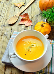 Pumpkin cream in autumn on a wooden table