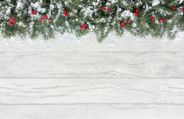 Fototapeta na wymiar Christmas Border with Snow Covered Red Berries and Fir