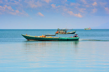 Fototapeta na wymiar Vietnamese Fishing Boats in Tranquil Sea up to Skyline
