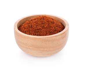 Pile of red paprika powder in wooden bowl on white background