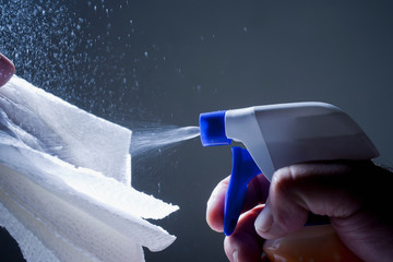 Cropped view of man spraying cleaning product of cloth