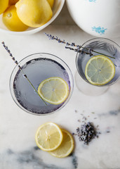 Lavender lemonade cocktails on white marble surface