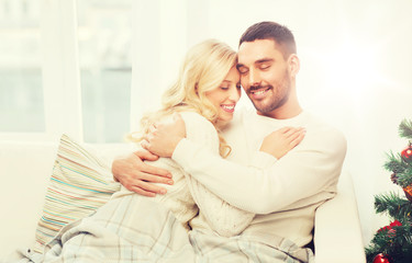 happy couple hugging on sofa at home