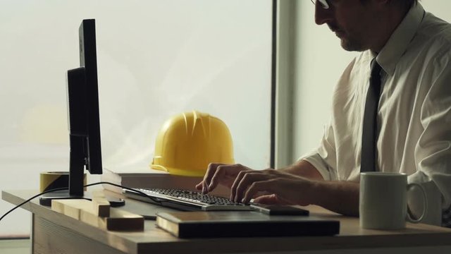 Construction engineer working on desktop computer using CAD software to sketch project in architecture studio office
