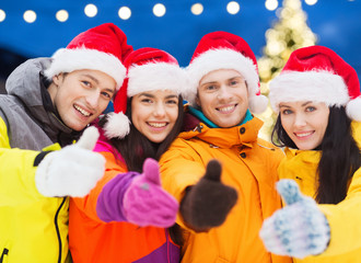 happy friends in santa hats and ski suits outdoors