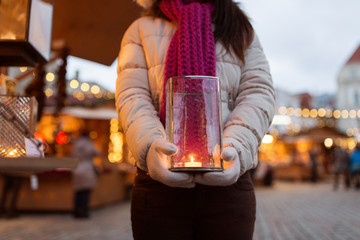 woman with candle in lantern at christmas market