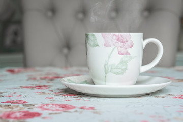 cup on a floral tablecloth