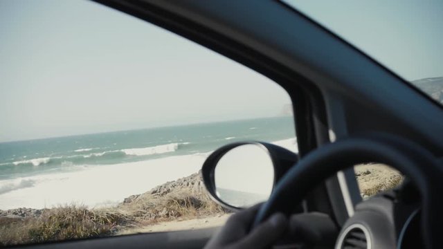 Rear view of tourist guy in rent car. Travel and summer vacation concepts.