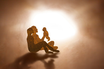 Family father holding baby in brown paper silhouette style.