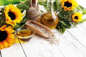 Sunflower oil, sunflower and seeds on white background