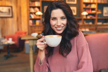 pretty woman drinking coffee in a cafe. Pleasure time