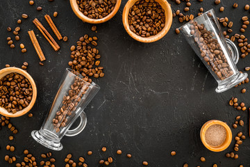 Ingredients for coffee. Roasted coffee beans and cinnamon on black background top view copyspace