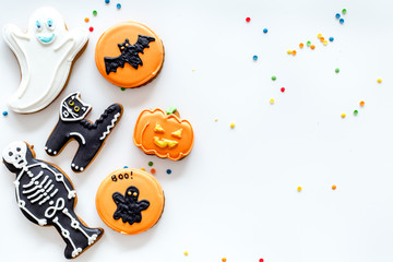 Halloween gingerbread cookies with pictures bat, pumpkin, skeleton, ghost on white background top view copyspace