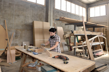 a woman working in a carpentry workshop - obrazy, fototapety, plakaty