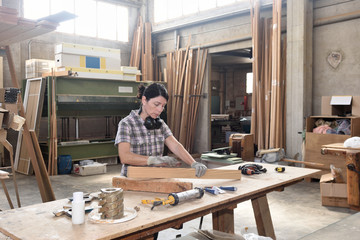 a woman working in a carpentry workshop,sand