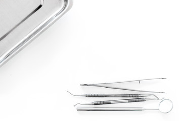 Set of dentists tools near cuvette on white background  top view copyspace