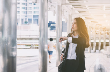 attractive young business woman waiting someone and very hurry at outdoor morning and look at her...