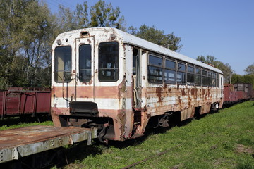 Obraz premium Old ruined steel passenger car. Rusty train on railway tracks.