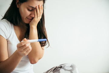 sad woman with pregnancy test
